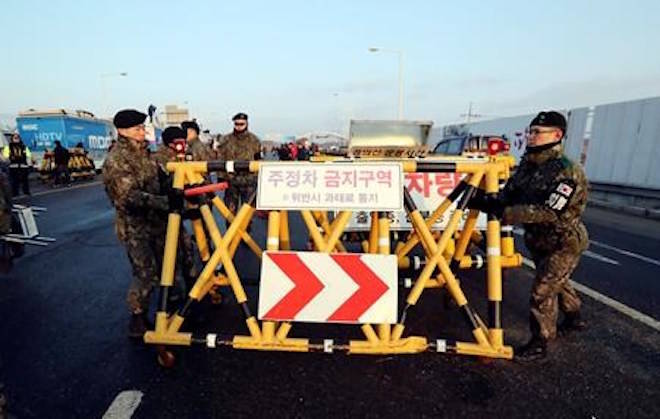 South Korean soldiers adjust barricade after South Korea’s delegation vehicles’ arriving at Unification Bridge, which leads to the Panmunjom in the Demilitarized Zone in Paju, South Korea, Tuesday, Jan. 9, 2018. North and South Korea were set to hold rare talks at their tense border Tuesday to discuss how to cooperate in next month’s Winter Olympics in the South and improve their long-strained ties. (AP Photo/Lee Jin-man)