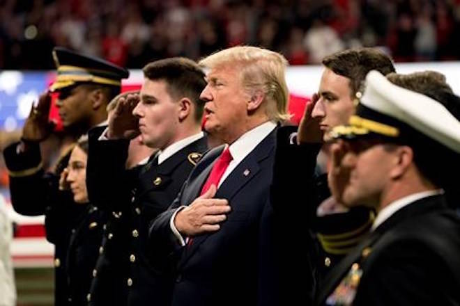 President Donald Trump stands on the field for the National Anthem before the start of the NCAA National Championship game at Mercedes-Benz Stadium between Georgia and Alabama, Monday, Jan. 8, 2018, in Atlanta. (AP Photo/Andrew Harnik)