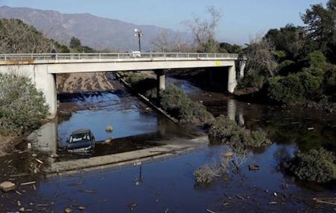 A car sits in flooded water on Highway 101 in Montecito, Calif., Thursday, Jan. 11, 2018. Rescue workers slogged through knee-deep ooze and used long poles to probe for bodies Thursday as the search dragged on for victims of Tuesday’s storm after mudslides slammed this wealthy coastal town. (AP Photo/Marcio Jose Sanchez)