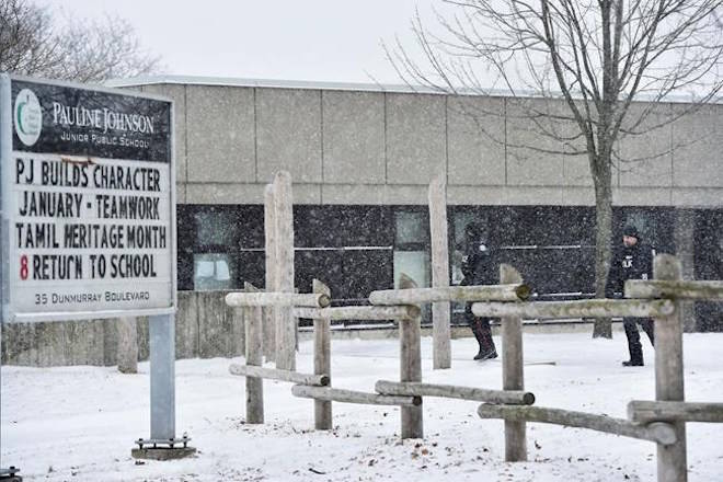 Two police officers walk around Pauline Johnson Junior Public School in Toronto on Monday, January 15, 2018. A Toronto police investigation has concluded that an incident reported by an 11-year-old girl who claimed her hijab was cut by a scissors-wielding man as she walked to school did not happen. THE CANADIAN PRESS/Frank Gunn