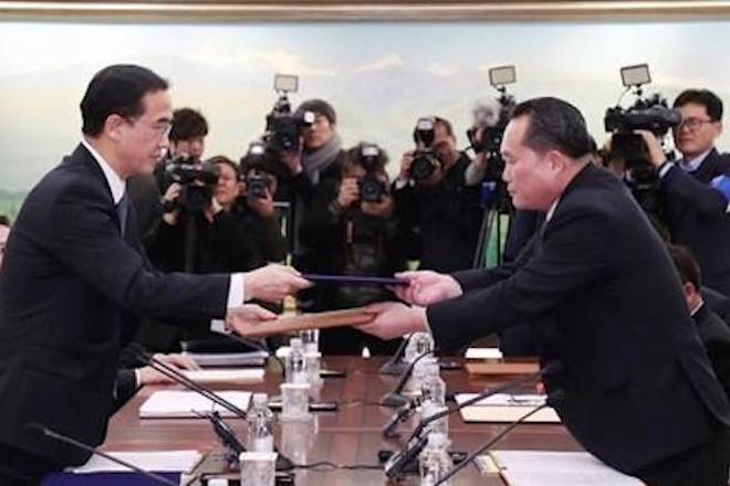 The head of North Korean delegation Ri Son Gwon, right, exchanges documents with South Korean Unification Minister Cho Myoung-gyon after their meeting at Panmunjom in the Demilitarized Zone in Paju, South Korea, Tuesday, Jan. 9, 2018. The rival Koreas took steps toward reducing their bitter animosity during rare talks Tuesday, as North Korea agreed to send a delegation to next month’s Winter Olympics in South Korea and reopen a military hotline. (Korea Pool/Yonhap via AP)