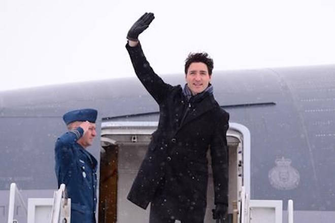 Canadian Prime Minister Justin Trudeau waves from the steps of his plane as he departs Ottawa for Davos, Switzerland for the annual World Economic Forum on Monday, January 22, 2018. THE CANADIAN PRESS/Paul Chiasson