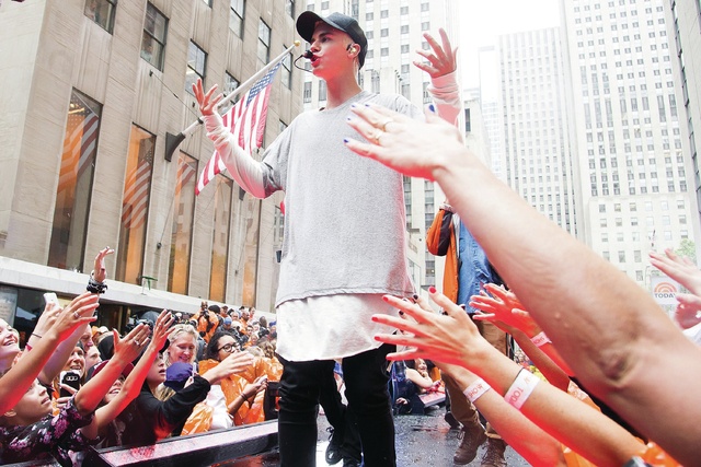 Justin Bieber performs in the rain on NBC’s “Today” show at Rockefeller Plaza on Thursday, Sept. 10, 2015, in New York. (Charles Sykes/Invision/AP)