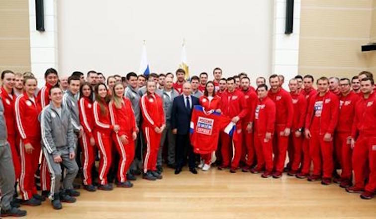 Russian President Vladimir Putin, holds a jersey while posing for a photo the Russian athletes who will take part in the upcoming 2018 Pyeongchang Winter Olympic Games in South Korea, at the Novo-Ogaryovo residence outside in Moscow, Russia, Wednesday, Jan. 31, 2018. (Grigory Dukor/Pool Photo via AP)