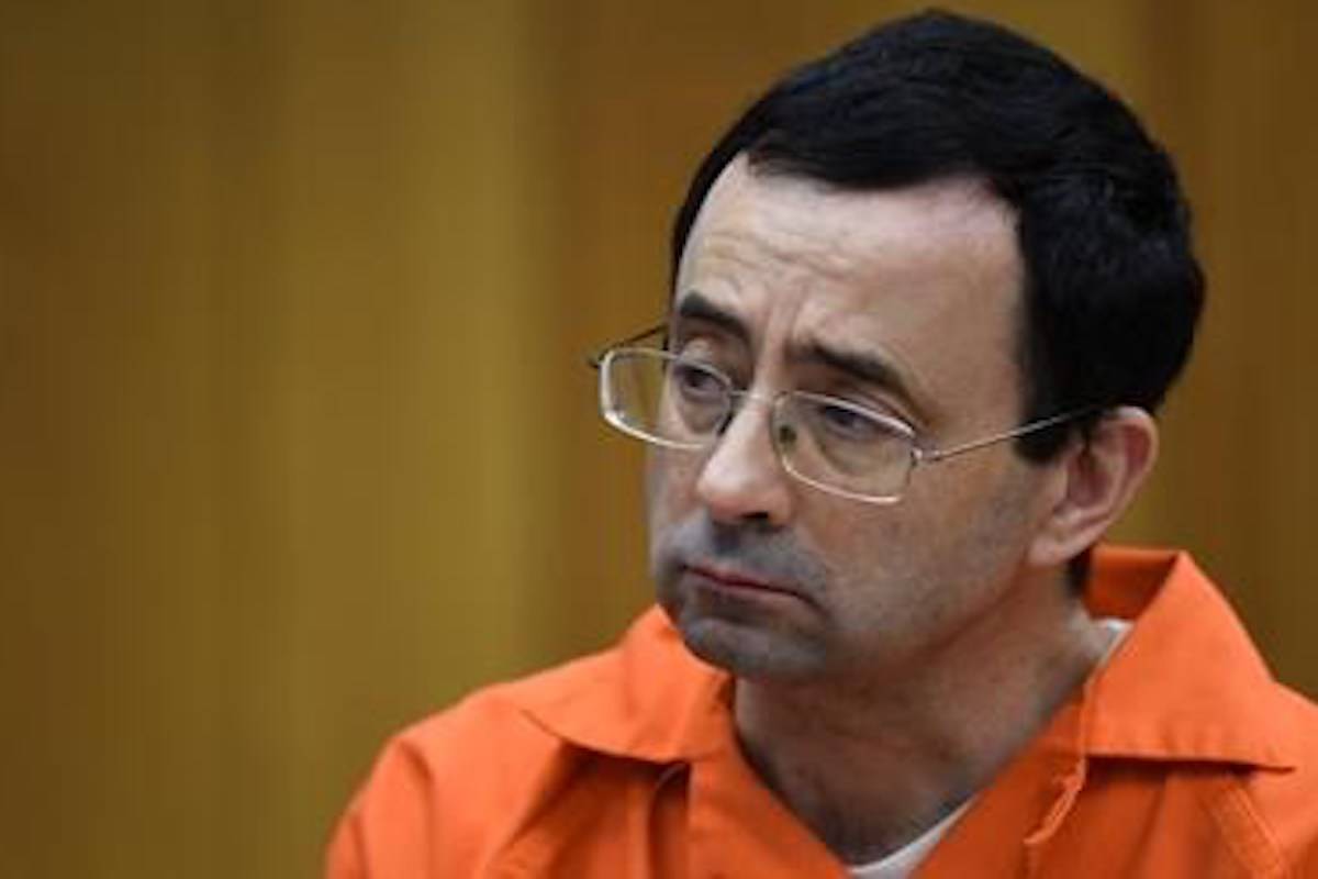 Larry Nassar listens as Rachael Denhollander gives her victim impact statement Friday, Feb. 2, 2018, in Eaton County Circuit Court, the second and final day of victim impact statements in Judge Janet Cunningham’s courtroom in Charlotte, Mich. He will be sentenced Monday. (Matthew Dae Smith/Lansing State Journal via AP)