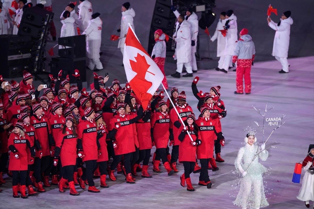 Tessa Virtue and Scott Moir carry the flags for Canada into PyeongChang Olympic stadium at the Opening Ceremony of the 2018 Pyeongchang Winter Olympics in South Korea (Vincent Ethier/COC)