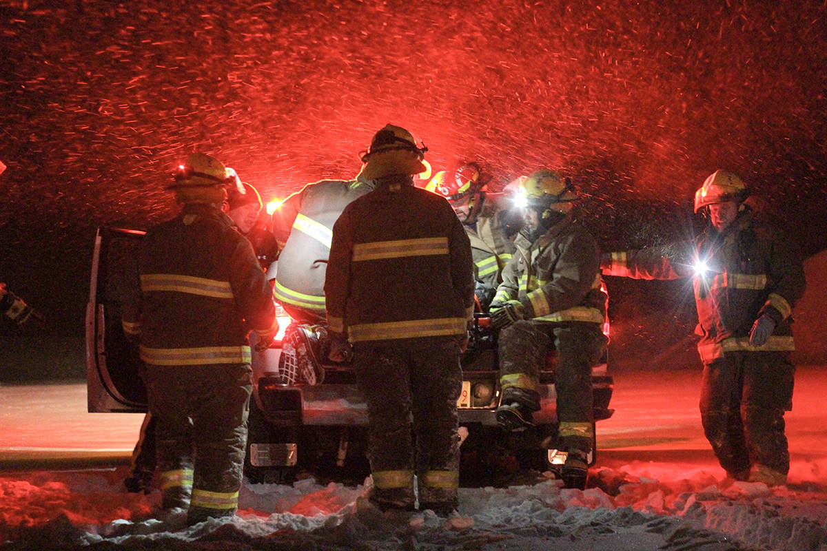 Ponoka County firefighters load the patient onto the back of the department’s pickup truck to get him to EMS crews. Ponoka RCMP located the man on foot as he was in a field. Photo by Jeffrey Heyden-Kaye