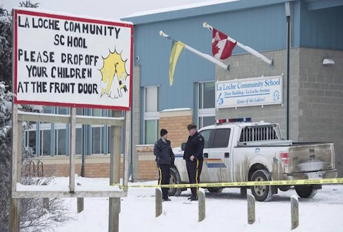 Members of the RCMP stand outside the La Loche Community School in La Loche, Sask. Monday, Jan. 25, 2016. THE CANADIAN PRESS/Jonathan Hayward