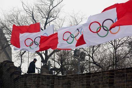 A security person stands near the Olympic flags during a ceremony to mark the start of the flag’s tour for the Winter Olympic Games Beijing 2022 at a section of the Great Wall of China on Tuesday. (Ng Han Guan/Ap Photo)