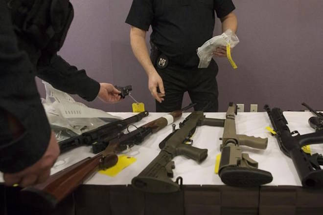 OPP officers prepare to bag a firearm after Ontario Provincial Police host a news conference in Vaughan, Ont., on Thursday, February 23, 2017. The Liberals are planning to introduce legislation in coming weeks to fulfil platform promises on firearms, including a requirement for “enhanced background checks” for anyone seeking to buy a handgun or other restricted gun.THE CANADIAN PRESS/Chris Young