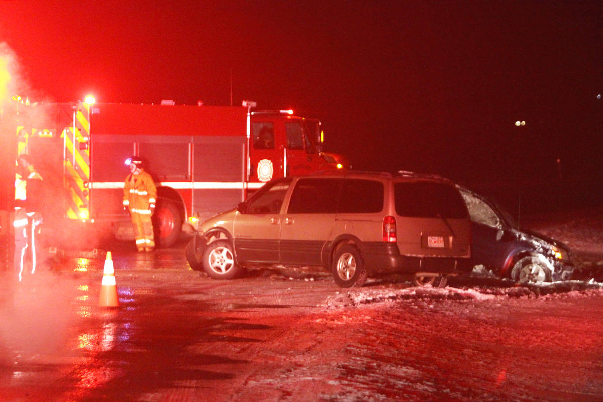 Bashaw Fire Department and EMS crews speak to a tow truck operator Friday after their truck was hit by another vehicle. At the time the operator was collecting a previous vehicle that hit the ditch due icy patches on the road. There were minor injuries from the incident.                                Photo by Jeffrey Heyden-Kaye