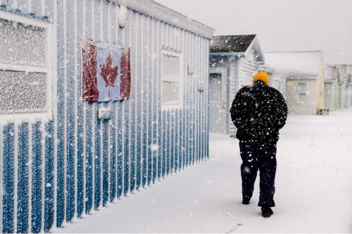 A pedestrian braves the elements on the boardwalk at Fisherman’s Cove in Eastern Passage, N.S. on Tuesday, March 13, 2018. (THE CANADIAN PRESS/Andrew Vaughan)