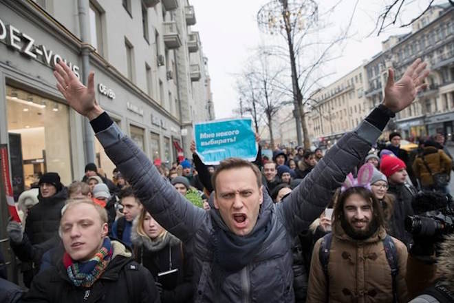 FILE - In this Sunday, Jan. 28, 2018 file photo, Russian opposition leader Alexei Navalny, center, attends a rally in Moscow, Russia. Navalny, the most vocal Putin critic, was barred from joining the presidential campaign due to a criminal conviction widely seen as a political punishment for his opposition activities and called for boycotting the vote. President Vladimir Putin seems self-assured and confident of victory in the election on Sunday, March 18, even as the Kremlin works hard to bolster turnout to make the result as impressive as possible. (AP Photo/Evgeny Feldman, File)