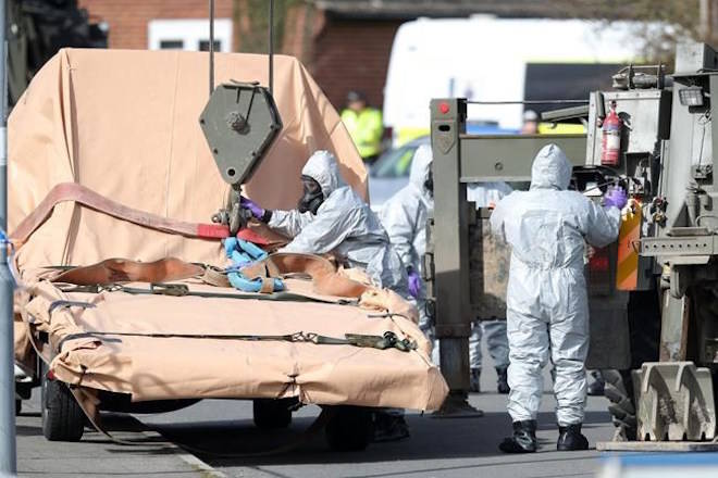 Soldiers wearing protective clothing prepare to lift a tow truck in Hyde Road, Gillingham, Dorset, England as the investigation into the suspected nerve agent attack on Russian double agent Sergei Skripal continues Wednesday March 14, 2018. The army cordoned off a road in Dorset on Wednesday as the investigated the attack on Sergei Skripal and his daughter Yulia. Authorities have cordoned off several sites in and near Salisbury, 90 miles (145 kilometers) southwest of London as part of their probe. (Andrew Matthews/PA via AP)