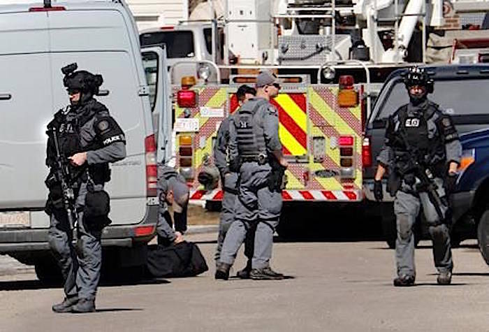 Calgary police tactical team members at the shooting scene of a police officer in Calgary, Alta. on Tuesday, March 27, 2018. THE CANADIAN PRESS/Larry MacDougal