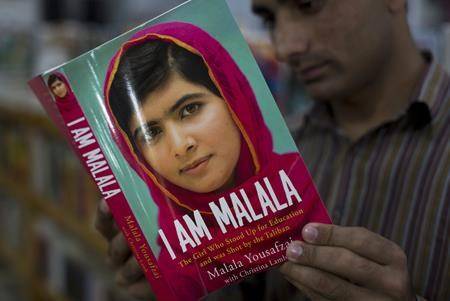 A Pakistani customer reads the book written by Malala Yousafzai, who survived a Taliban attack, in Islamabad, Pakistan. (AP Photo/B.K. Bangash)