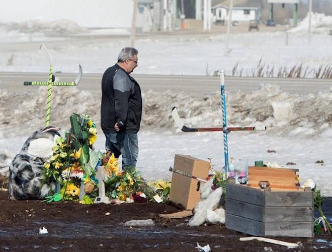 Myles Shumlanski looks around a makeshift memorial at the intersection of a fatal bus crash near Tisdale, Sask., Tuesday, April, 10, 2018. Shumlanski’s son Nick was one of the survivors of a fatal bus crash.THE CANADIAN PRESS/Jonathan Hayward