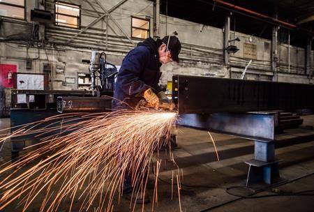 A worker uses a grinder on a steel at George Third & Son Steel Fabricators and Erectors, in Burnaby. (Darryl Dyck/The Canadian Press)