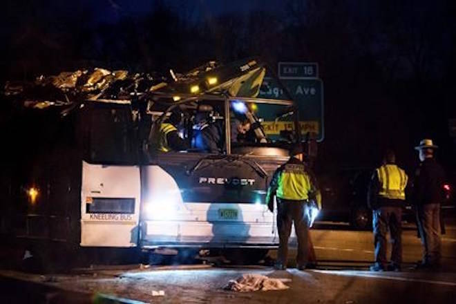 A bus that was carrying teenage passengers sits on the side of a highway after it hit an overpass on the Southern State Parkway in Lakeview, N.Y., Monday, April 9, 2018. The charter bus carrying teenagers returning from a spring break trip struck a bridge overpass on Long island, seriously injuring several passengers and mangling the entire length of the top of the bus. (AP Photo/Kevin Hagen)
