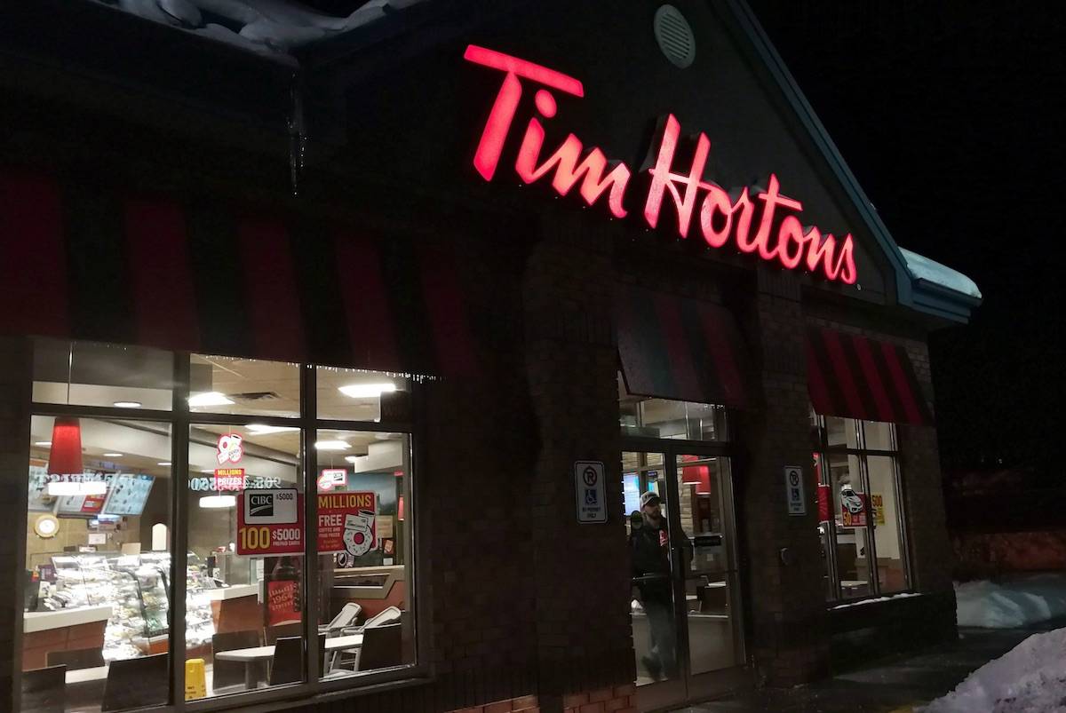 A customer walks out of a Tim Hortons restaurant in Newcastle, Ont., on Sunday Feb. 11, 2018. THE CANADIAN PRESS/Doug Ives