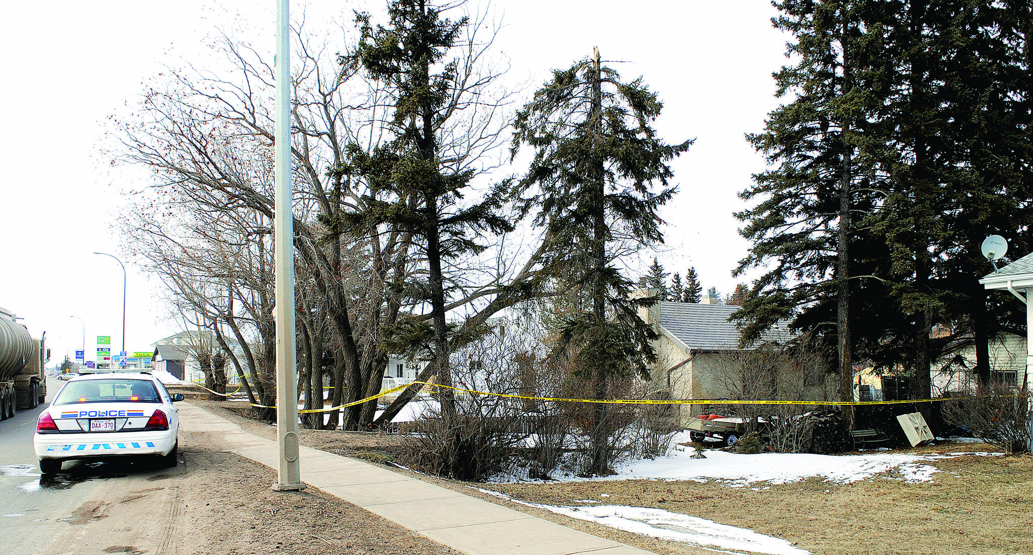 A Red Deer RCMP officer guards two homes cordoned off in Stettler. Police charged a 51-year-old Stettler man with second degree murder.                                File photo