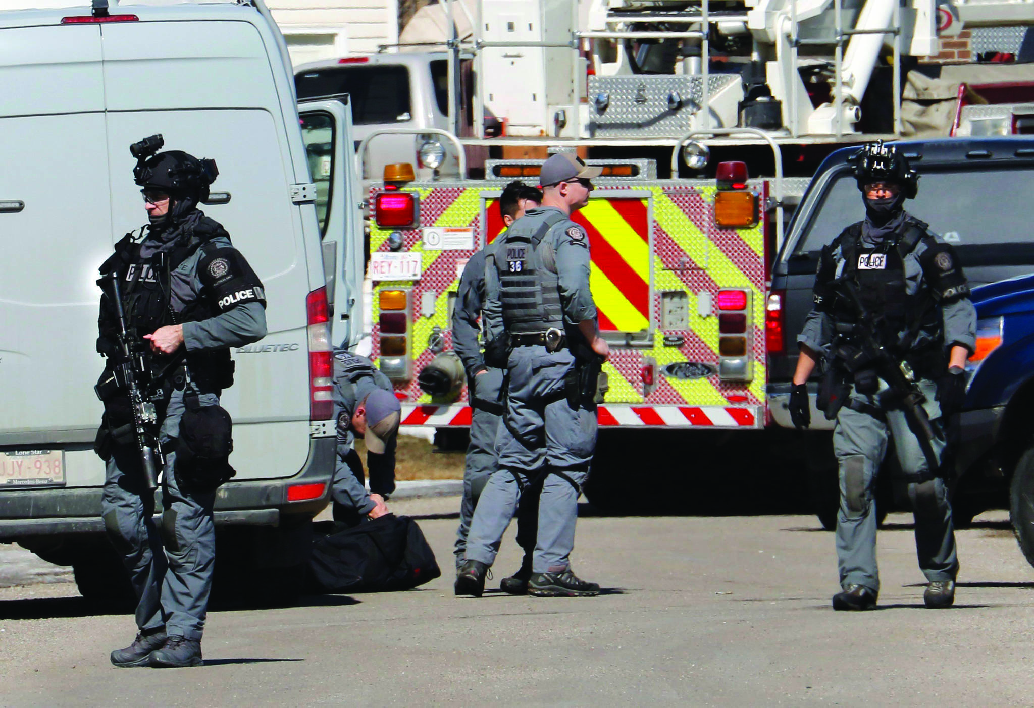 Calgary police tactical team members at the shooting scene of a police officer in Calgary on Tuesday, March 27, 2018. (Larry MacDougal/The Canadian Press)