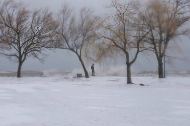 A man walks along the boardwalk on Toronto’s waterfront as a the city is hit by a storm on Sunday, April 15, 2018. THE CANADIAN PRESS/Chris Young
