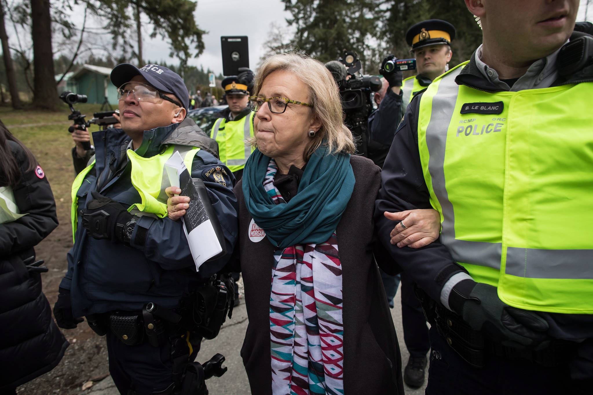 Federal Green Party Leader Elizabeth May, centre, is arrested by RCMP officers after joining protesters outside Kinder Morgan’s facility in Burnaby, B.C., on Friday March 23, 2018. (Darryl Dyck/The Canadian Press)