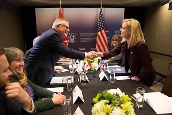 Public Safety Minister Ralph Goodale reaches across a table to shake hands with Kirstjen Nielsen, United States Secretary of Homeland Security during a G7 Foreign and Security Ministers meeting in Toronto on Monday, April 23, 2018. THE CANADIAN PRESS/Chris Young