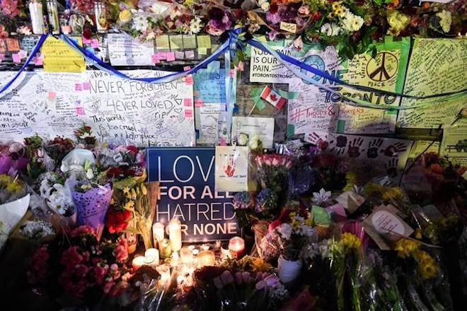 Flowers, notes and candles are piled high at a vigil on Yonge Street in Toronto, Tuesday, April 24, 2018. Ten people were killed and 14 were injured in Monday’s deadly attack in which a van struck pedestrians in northern Toronto. THE CANADIAN PRESS/Galit Rodan