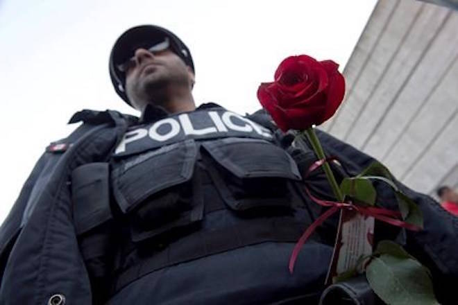 A red rose adorns a police officer at a vigil remembering the victims of Monday’s deadly van attack, at Mel Lastman Square in Toronto on Sunday, April 29, 2018. THE CANADIAN PRESS/Frank Gunn
