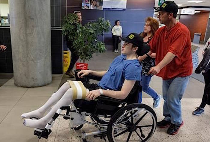 Humboldt Broncos hockey player Ryan Straschnitzki, who was paralyzed following a bus crash that killed 16 people, is wheeled by his father Tom as his mother Michelle, centre, walks beside in Calgary, Alta., Wednesday, April 25, 2018.THE CANADIAN PRESS/Jeff McIntosh