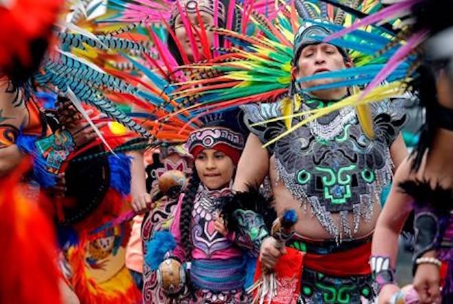 FILE - In this Monday, May 1, 2017, file photo, members of Ce Atl, an Aztec-inspired spiritual and cultural preservation group, dance near the front of a march for worker and immigrant rights at a May Day event in Seattle. (AP Photo/Elaine Thompson, File)