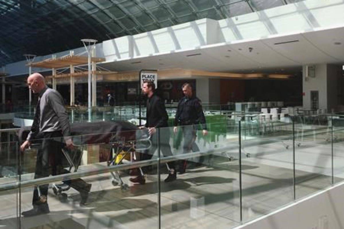 Medical examiners escort a body found in a wall in the women’s washroom in the Core Shopping Centre in Calgary on Monday, April 30, 2018. Calgary police are investigating after a body was found in a wall in a downtown mall bathroom. (Lauren Krugel/The Canadian Press)