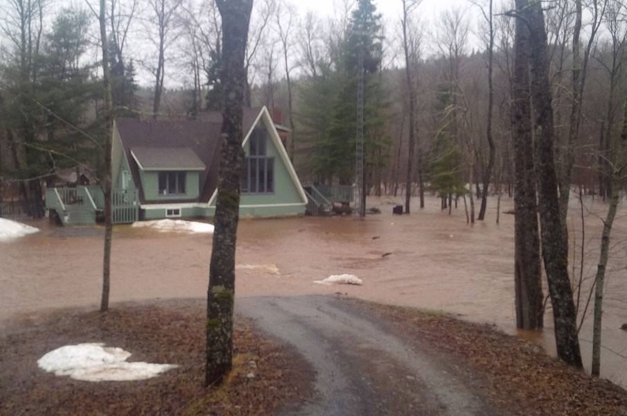 A cottage in Waterford, N.B., is surrounded by flood waters on Wednesday, April 16, 2014. (THE CANADIAN PRESS/Gilles Daigle)
