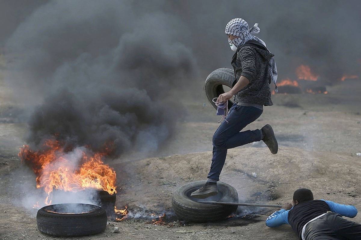 Palestinian protesters burn tires during a protest on the Gaza Strip’s border with Israel, Monday, May 14, 2018. Thousands of Palestinians are protesting near Gaza’s border with Israel, as Israel prepared for the festive inauguration of a new U.S. Embassy in contested Jerusalem. (AP Photo/Khalil Hamra)