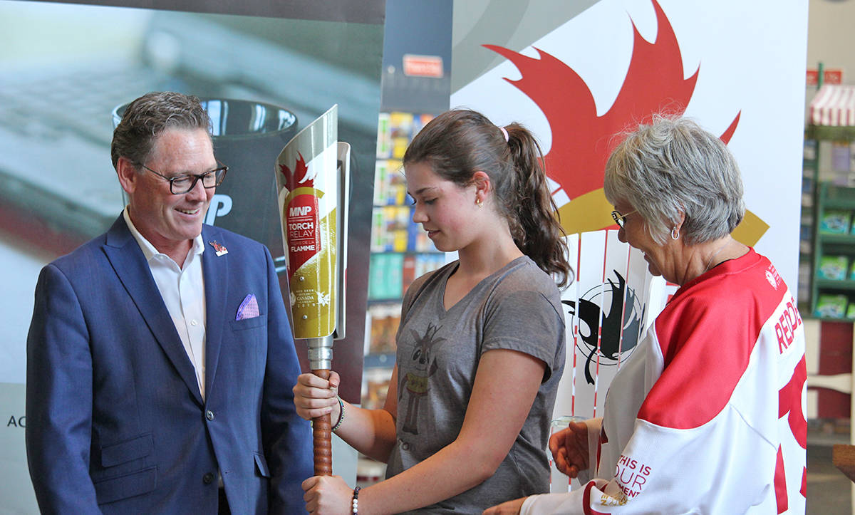 TORCH RELAY - Randy Mowat of MNP and Lyn Radford of the Games, watch on excitedly as Mackenzie Van Damme brings out the torch for the MNP Canada Games Torch Relay. Carlie Connolly/Red Deer Express