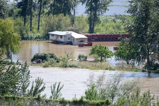 A home is surrounded by flood waters from the Similkameen River near Keremeos, in the Southern Interior of British Columbia, on Tuesday, May 15, 2018. THE CANADIAN PRESS/Jonathan Hayward