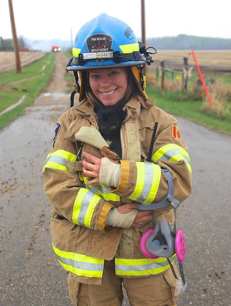 Taking care of others: A member of the Bentley District Fire Department holds a puppy that was just rescued from a structure fire May 17. The department assisted the Lacombe Fire Department in a mutual aid call. Photo courtesy of Kathi Issler, Bentley District Fire Department