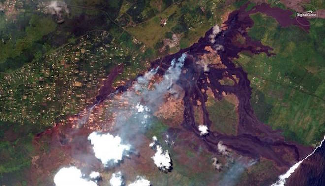 This May 23, 2018, Satellite photo provided by DigitalGlobe shows lava coming out of fissures caused by Kilauea volcano, running towards the Puna coast, lower right, along Malama Ki Forest Reserve recreation area in Pahoa, Hawaii. Puna Geothermal Venture, a geothermal energy plant is seen at upper middle. The Leilani Estates neighborhood, where the volcano has been gushing lava on the big island of Hawaii for the past three weeks, is seen at center left part. (Satellite Image Â©2018 DigitalGlobe, a Maxar company via AP)