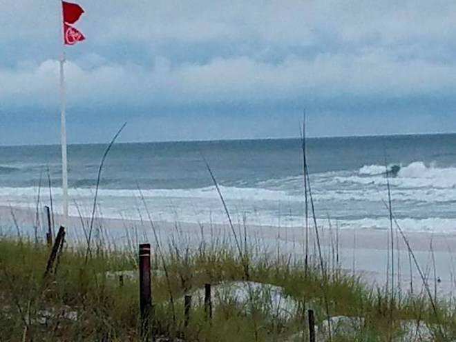 Red flags signal no swimming as a subtropical storm approaches Monday, May 28, 2018, in Fort Walton Beach, Fla. The storm gained the early jump on the 2018 hurricane season as it headed toward anticipated landfall sometime Monday on the northern Gulf Coast, where white sandy beaches emptied of their usual Memorial Day crowds. (AP Photo/Diana Heidgerd)