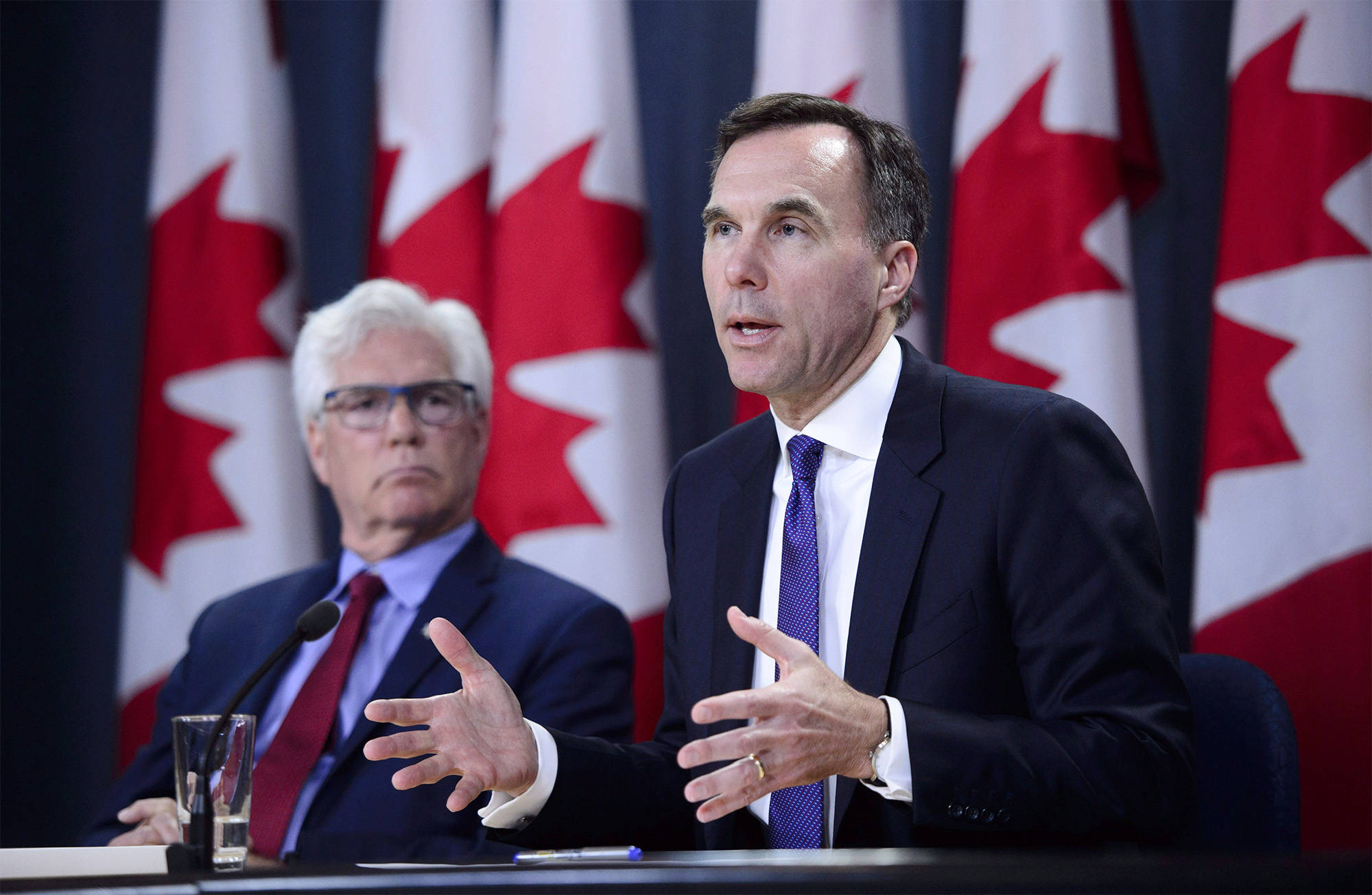 Finance Minister Bill Morneau and Natural Resources Minister James Carr speak at the National Press Theatre during a press conference in Ottawa on Tuesday, May 29, 2018. THE CANADIAN PRESS/Sean Kilpatrick