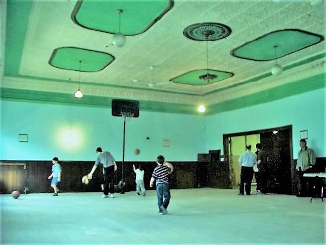 People play basketball in St. Stephen, N.B. in this undated handout photo. For years, it lay hidden under drab blue carpet on the top floor of a building that housed everything from a printing press company and dance hall to a gym and storeroom for a miscellany of goods. But in 2010 when a fire swept through the historic structure in St. Stephen, N.B., the cleanup uncovered a buried treasure that’s now at the centre of a transatlantic debate over a little-known piece of basketball lore. THE CANADIAN PRESS/Handout/Peter Corby