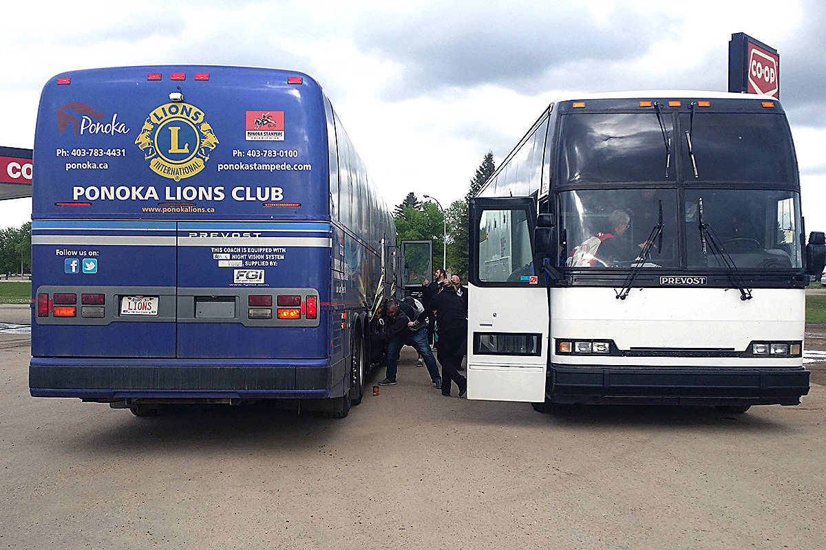 A contingent of Special Olympics athletes and coaches transfer luggage, equipment and passengers to a new bus from the Ponoka Lions Club bus in Ponoka after being rescued off Highway 2 following a nearly tragic breakdown of their first bus. Photo by Jordie Dwyer