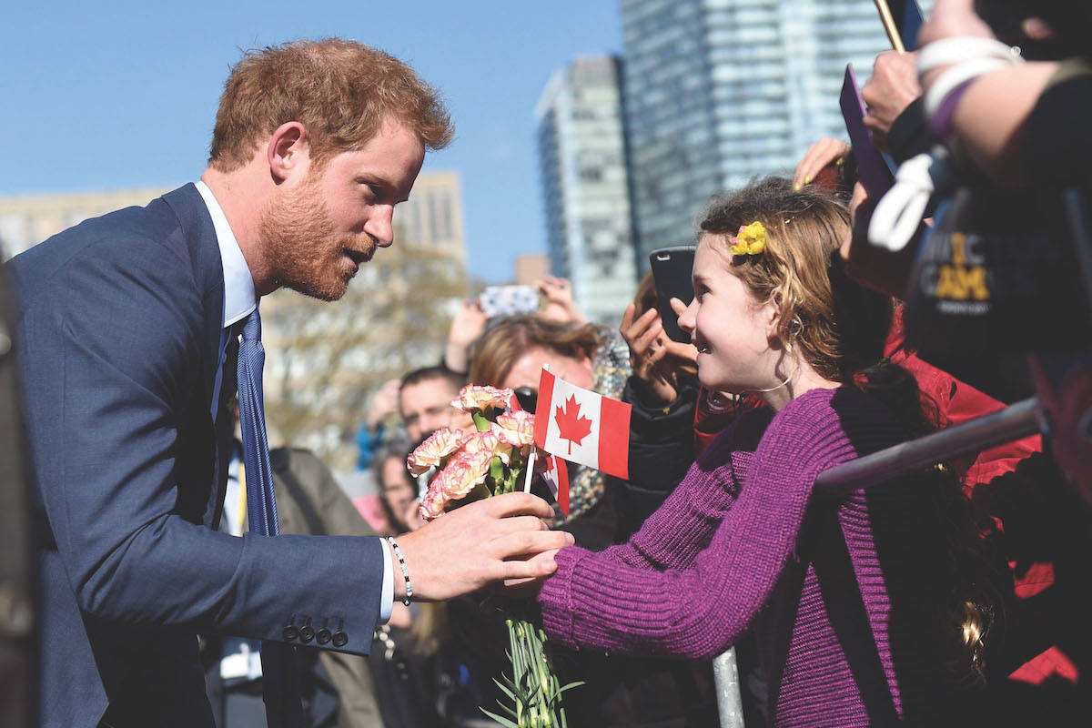 Prince Harry greets a girl outside Queen’s Park in Toronto, Monday, May 2, 2016, during his visit to promote the 2017 Invictus Games. THE CANADIAN PRESS/Nathan Denette