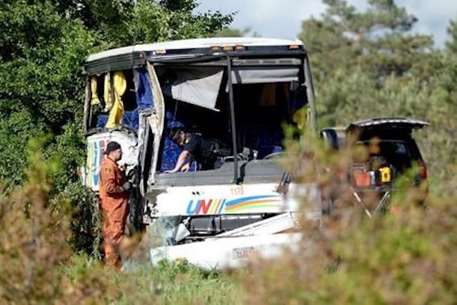 OPP officers work at the site of a crash involving a tour bus on Highway 401 West, near Prescott, Ont. THE CANADIAN PRESS/Justin Tang