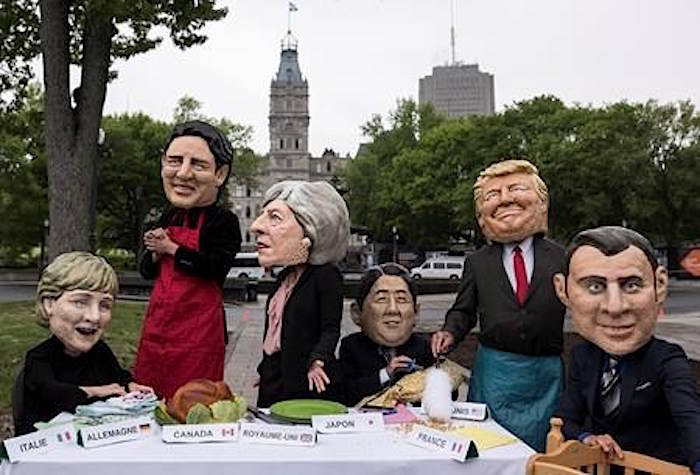 Activists stage a demonstration while wearing masks of G7 leaders, from left to right, Angela Merkel, Justin Trudeau, Theresa May, Shinzo Abe, Donald Trump, and Emmanuel Macron prior to the G7 Summit in Quebec City on Thursday, June 7, 2018. THE CANADIAN PRESS/Darren Calabrese
