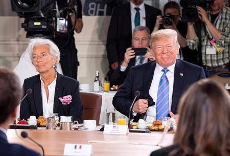 U.S. President Donald Trump takes his seat after arriving late for the G7 and Gender Equality Advisory Council Breakfast, as IMF Managing Director Christine Lagarde looks on, left, at the G7 leaders summit in La Malbaie, Que., on Saturday, June 9, 2018. (Justin Tang/The Canadian Press)