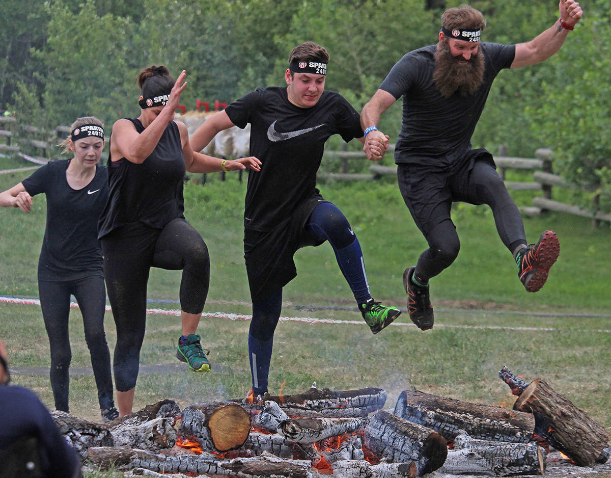 I AM SPARTAN - Runners jumped over the fire, the final obstacle of this weekend’s Spartan Race at Heritage Ranch. Carlie Connolly/Red Deer Express
