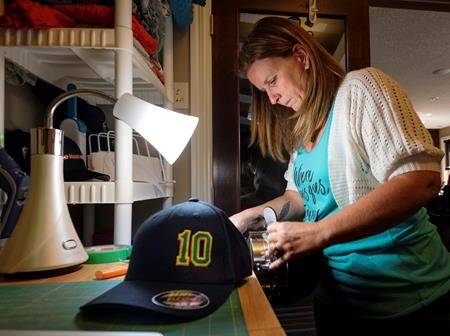 Susan Bissonnette works on hats at her home in Airdrie, Alta., Thursday, June 7, 2018. She volunteered to make Ryan Straschnitzki hats as part of a fund raising campaign for the injured Humboldt Broncos player and the extra care he will need once released from hospital. (Jeff McIntosh/The Canadian Press)